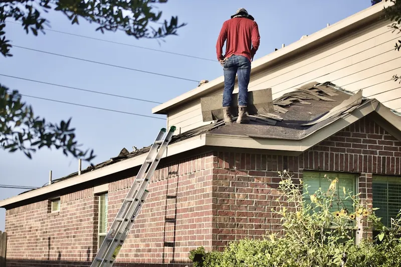 Professional roofer working on a residential roof in Williamsburg Village